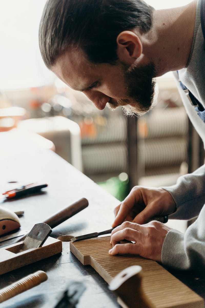 Man in Gray Long Sleeve Shirt Writing on White Paper