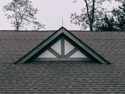 a roof with a triangle shaped window on top of it